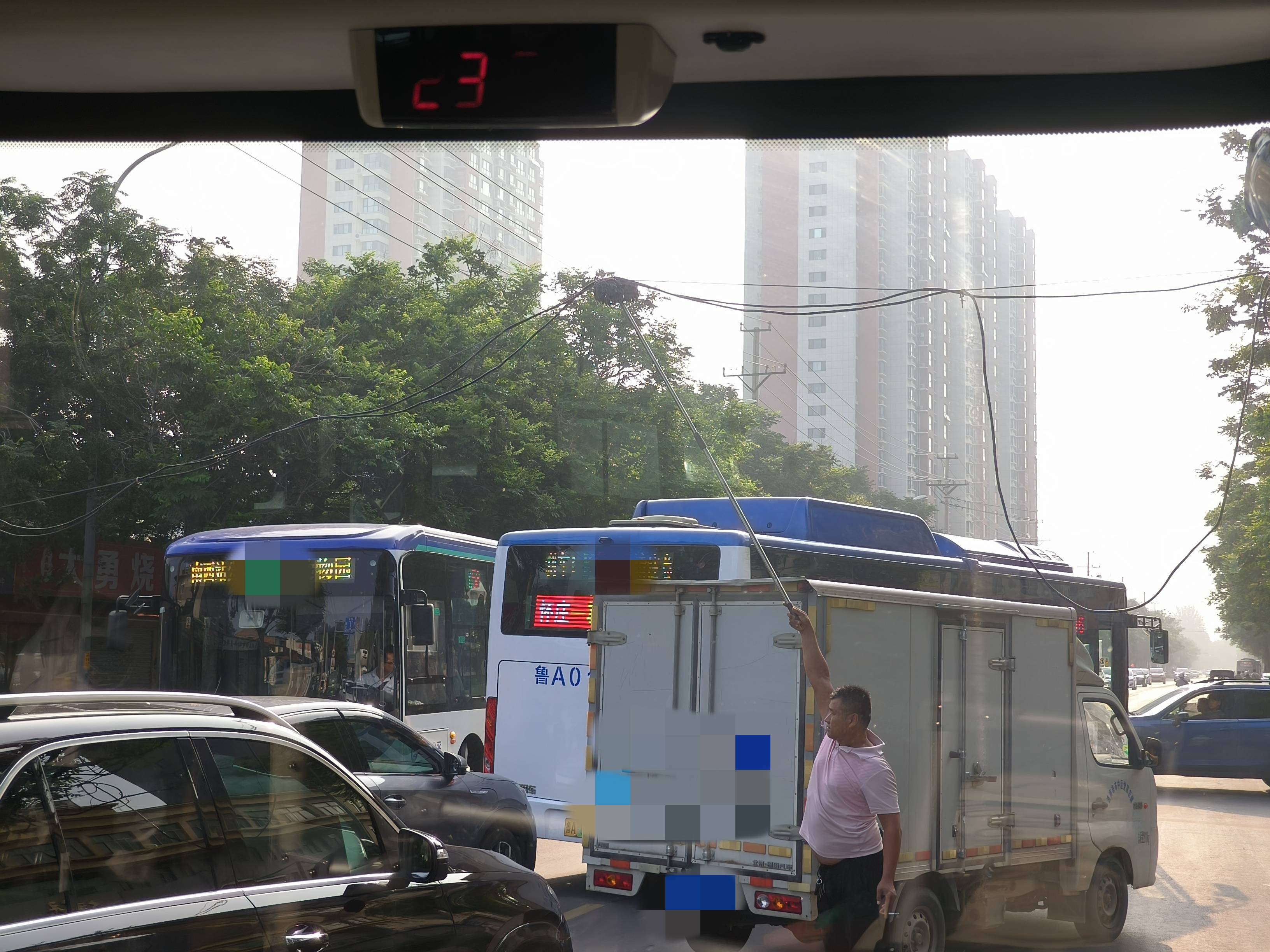 左手夹着烟右手举拖把，济南早高峰时一电线掉落，粉衣大哥化解交通拥堵松弛感拉满！